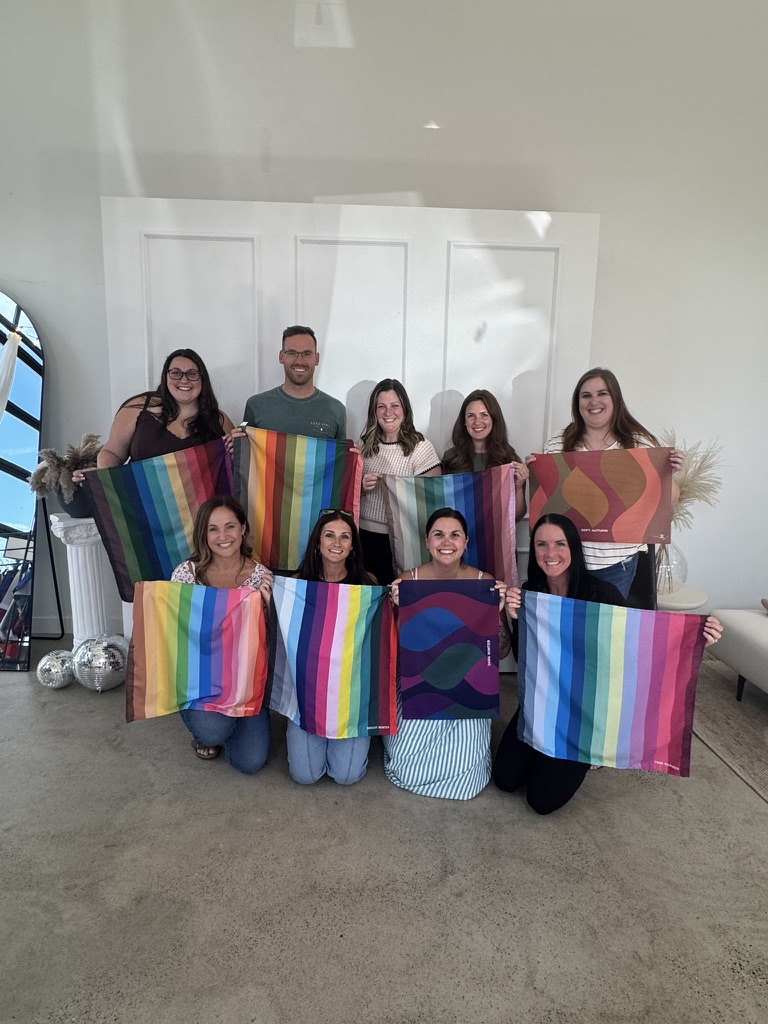 Nine guests holding up their season palettes at a Color Celebration