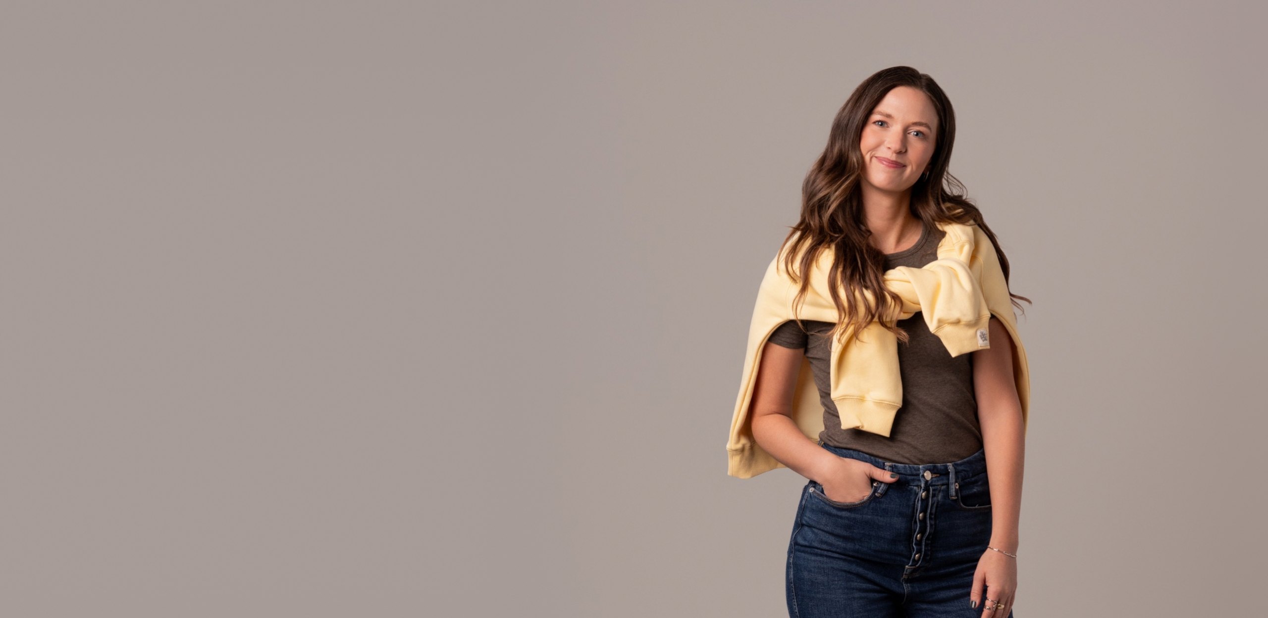 Nicole, Kibbe stylist at The Stylery, wearing high-rise jeans and a yellow sweater over her shoulders