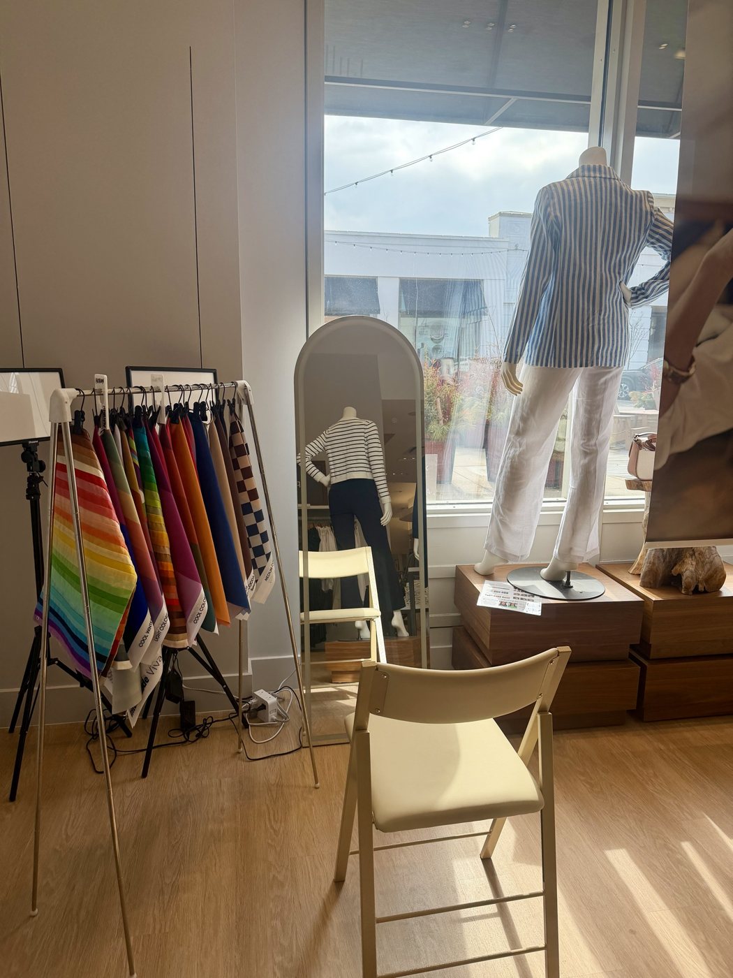 A color analysis pop-up station at J.Jill, with a drape rack, lighting, mirror and chair by the shop window
