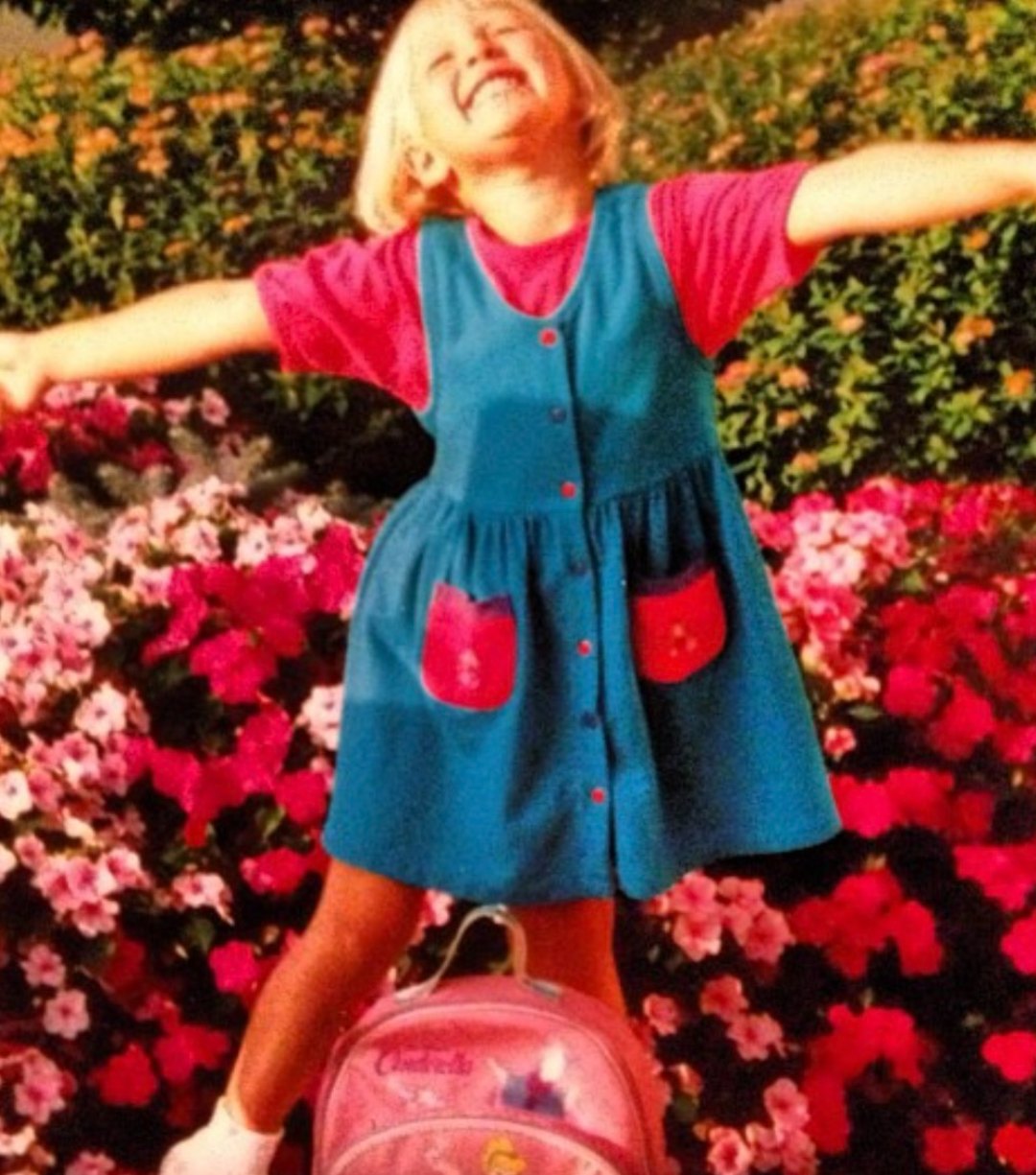 Nicole as a little girl in a turquoise dress and hot pink top